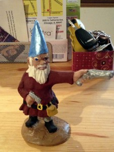 Zombies beware! This gun-wielding gnome just got a little more dangerous with a 'stache and matching satchel.